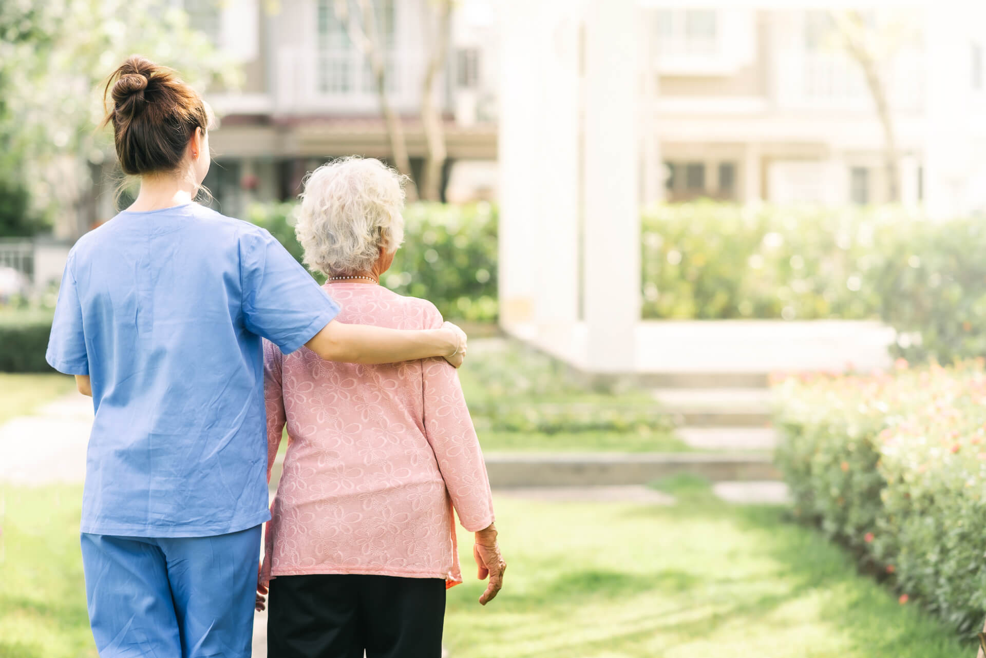 nurse-caregiver-support-walking-with-elderly-woman-outdoor (1) (1)